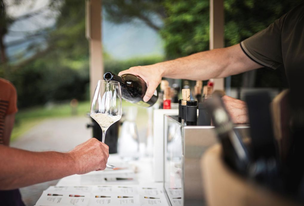 Una persona versa un bicchiere di vino