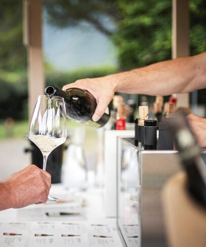 Someone pours a glass of wine