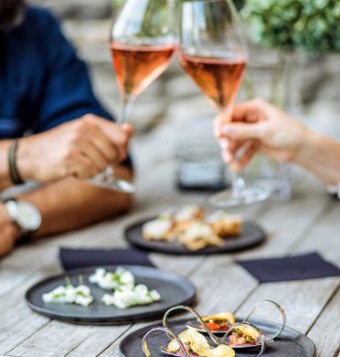 Two people are clinking their aperitif glasses