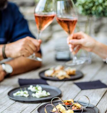 Two people are clinking their aperitif glasses